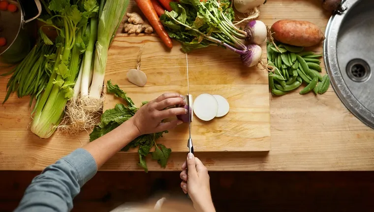 can-dogs-eat-turnips-2 High angle shot of a woman cutting up vegetables on a cutting board